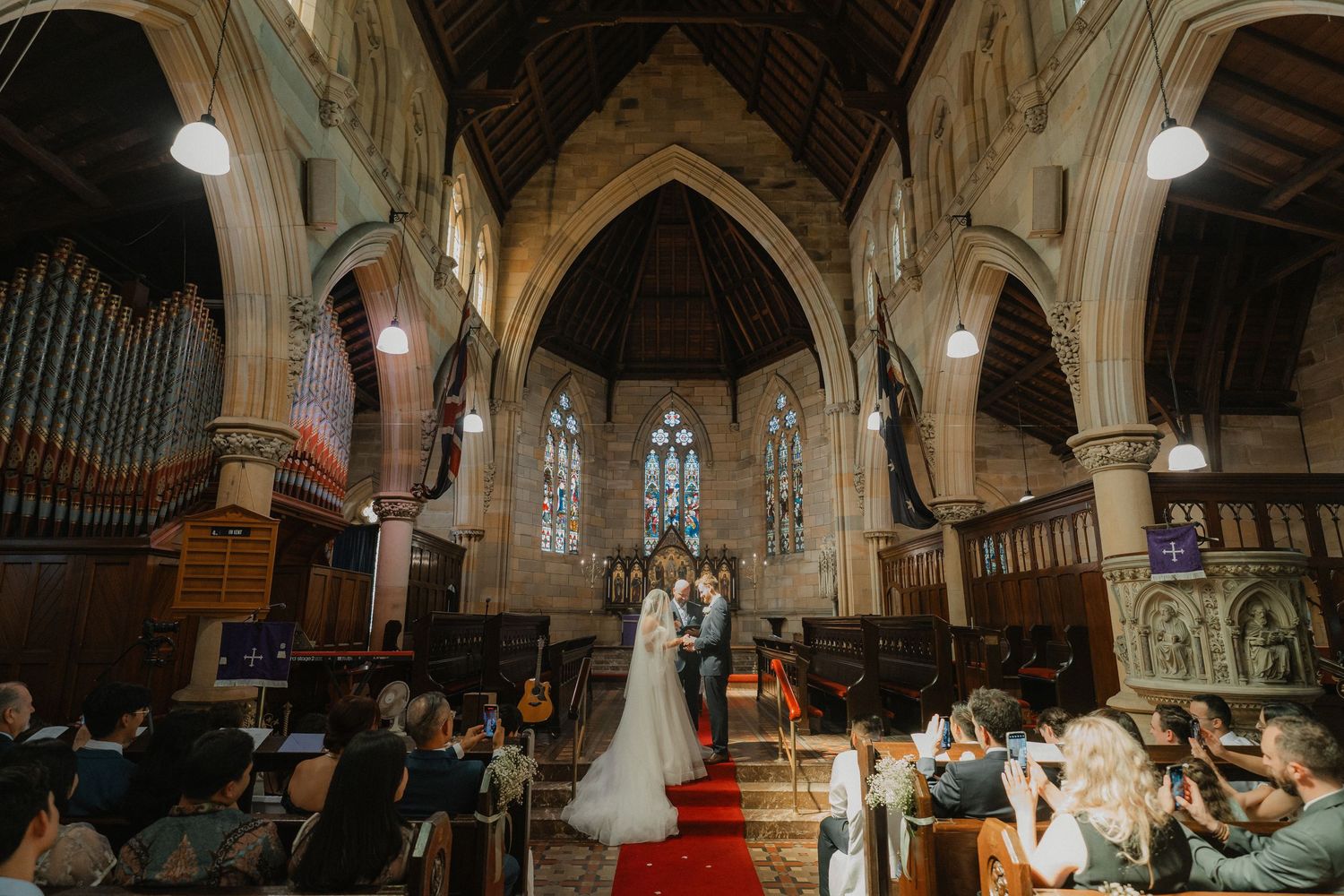 Wide angle view of a traditional church wedding ceremony with vaulted ceilings and ornate architectural details.