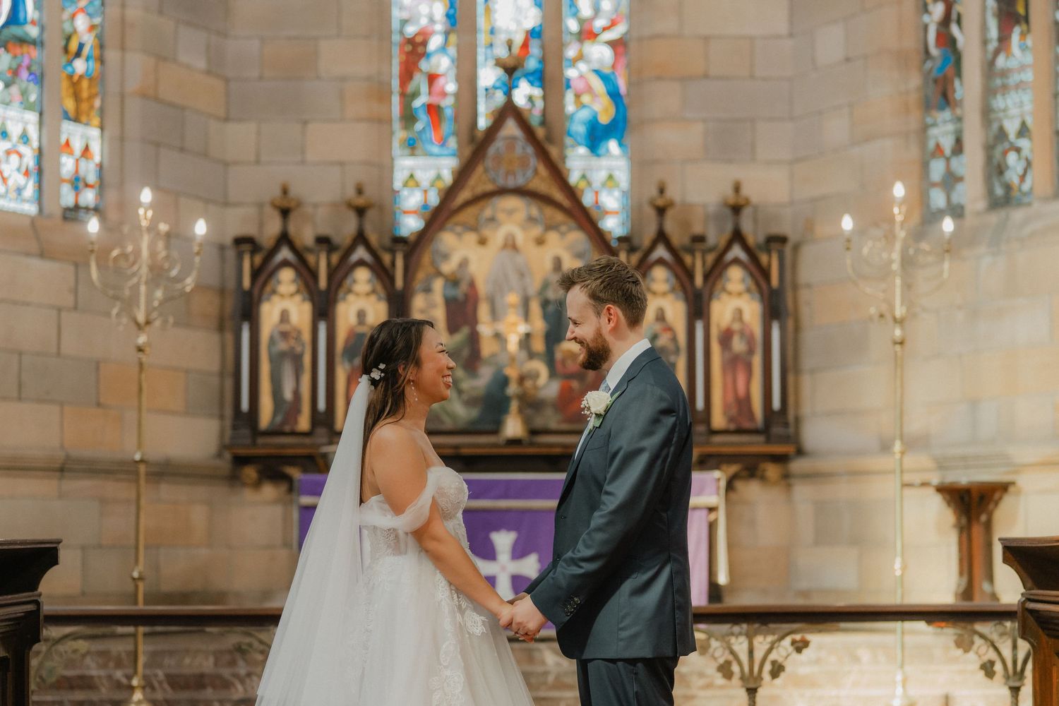 Traditional church wedding ceremony in a historic stone chapel with beautiful stained glass windows.