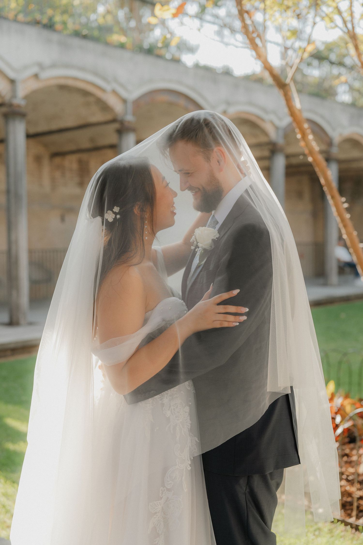 Romantic wedding portrait sequence showing a couple embracing under a veil at an outdoor venue.