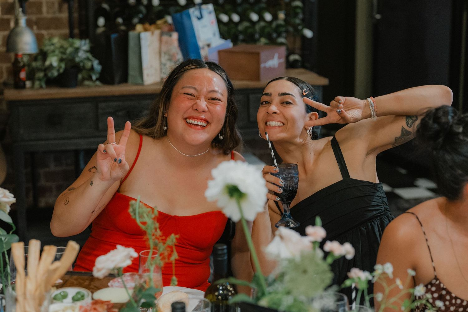 Friends celebrating at a reception table decorated with white flowers.