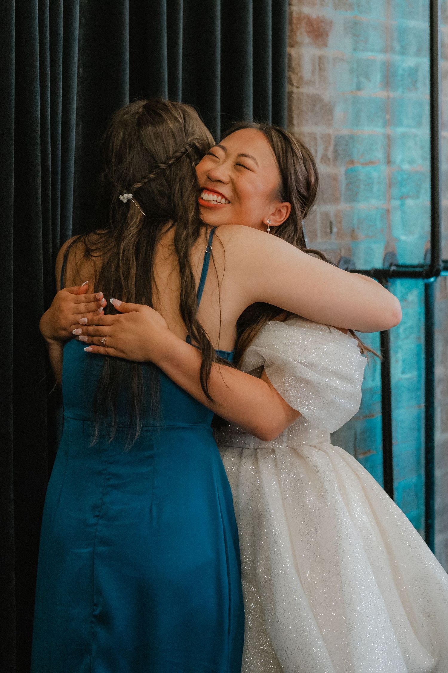 Two guests share an emotional embrace during a wedding celebration.