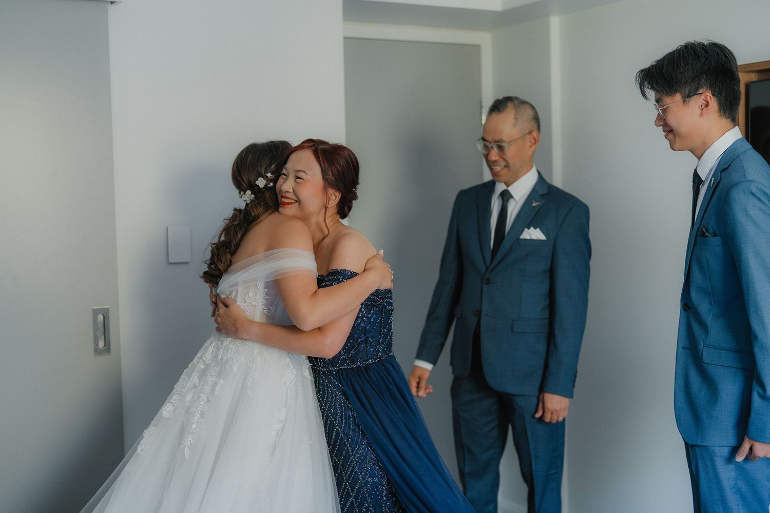 Emotional moments shared between wedding party members in a hotel room setting.