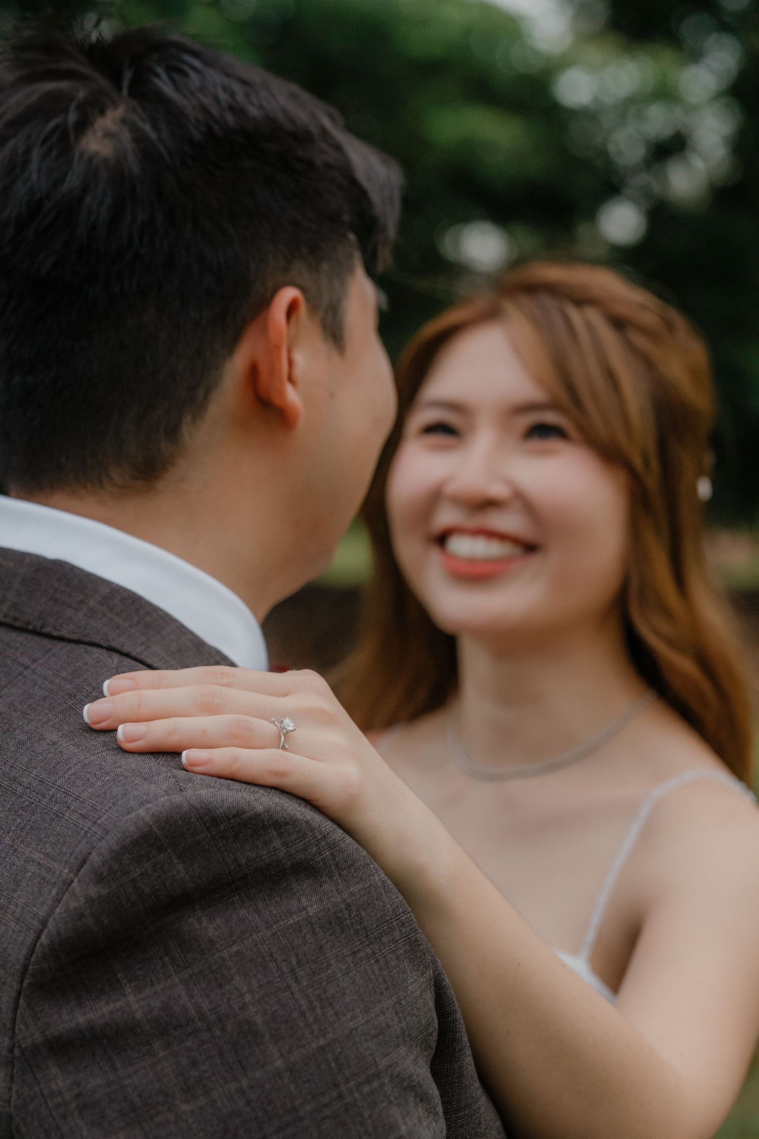 A tender wedding moment captured outdoors as a couple shares an intimate exchange in natural lighting.