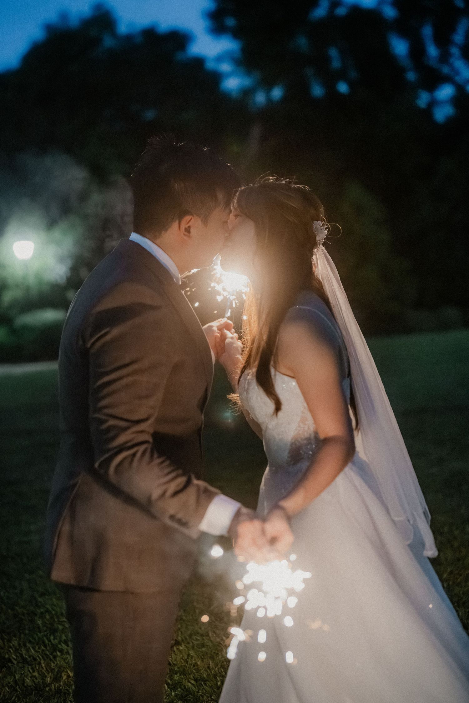 Romantic couple shares an intimate moment with sparklers during their twilight wedding photoshoot.