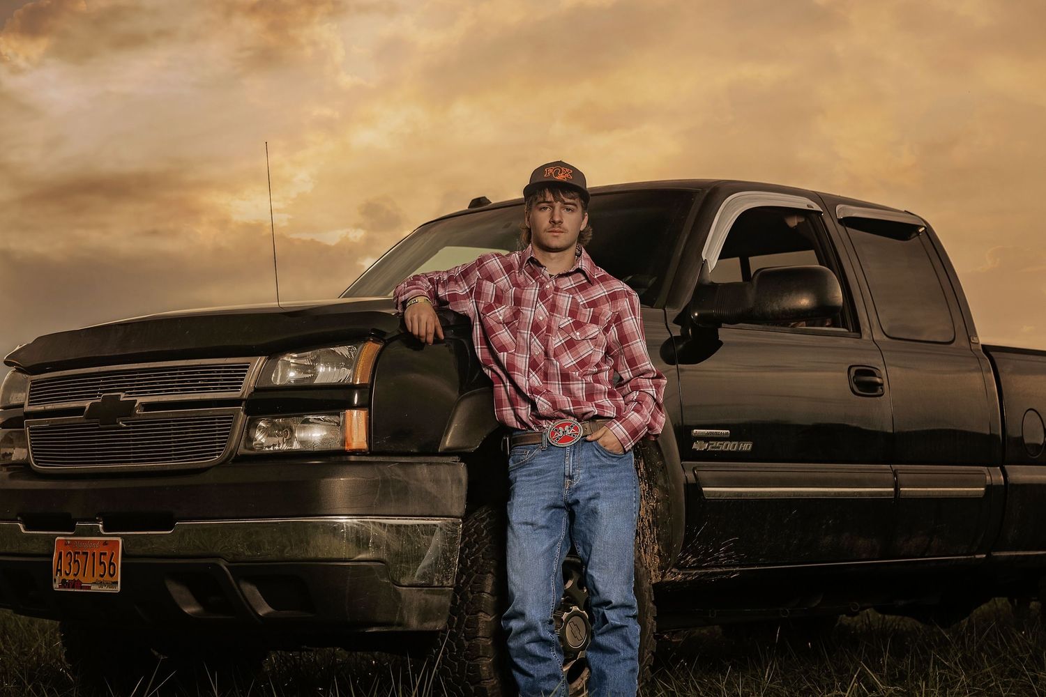 Rustic senior photos with vintage trucks at sunset.