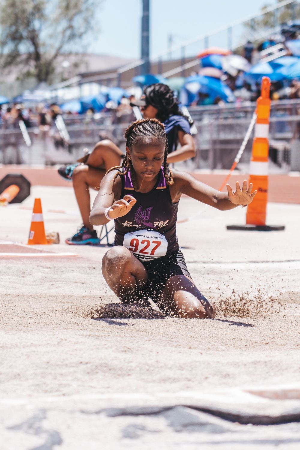 Sequence of an athlete performing a long jump landing in the sand pit during competition.
