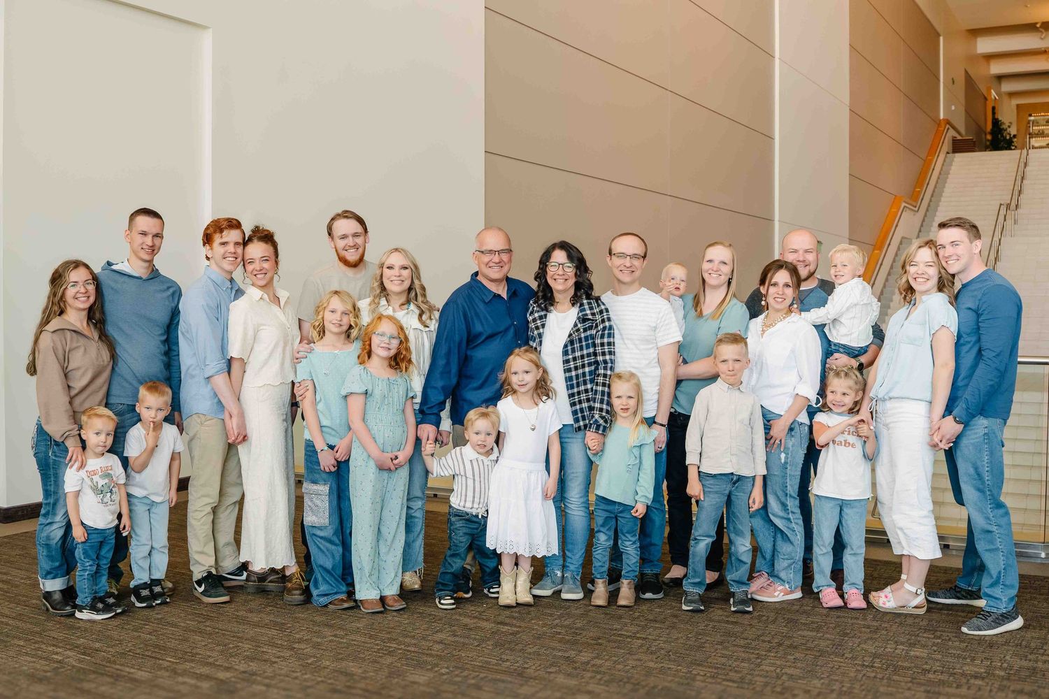 Des Moines Iowa family photographer – large extended family group portrait indoors, multi-generational smiles in modern venue