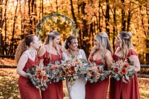 bride and bridesmaids laugh at fall golden hour wedding at The Barn at Everthine