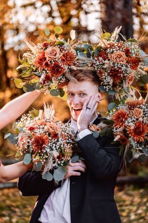 Bouquet circles groom as he strikes a pose at fall golden hour wedding at The Barn at Everthine