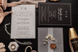 close up of wedding invitations, jewelry, and perfume