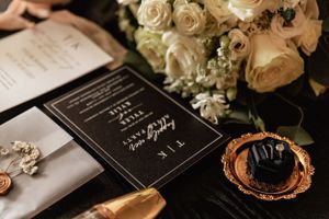 close up of wedding invitations, jewelry, and perfume