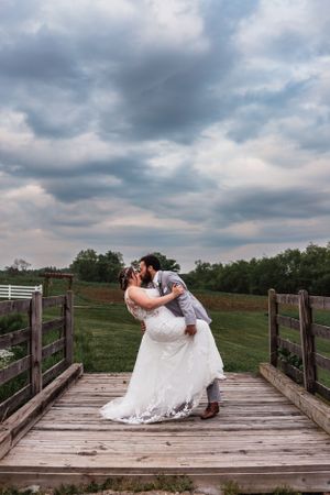 bride and groom dip kiss with storm clouds in the background at Lingrow Farm wedding