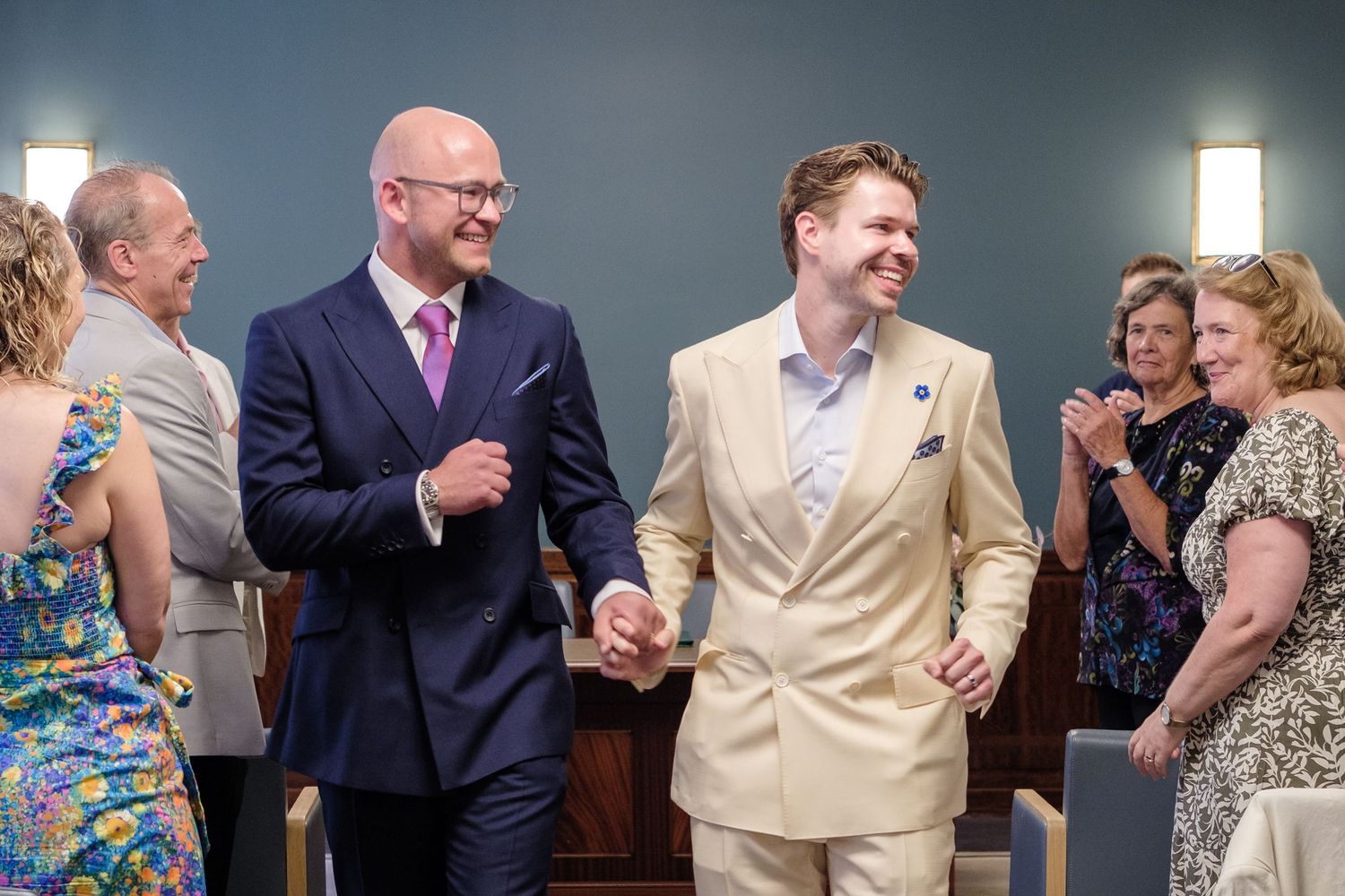 Happy guests mingle and chat during a wedding reception celebration in elegant attire.