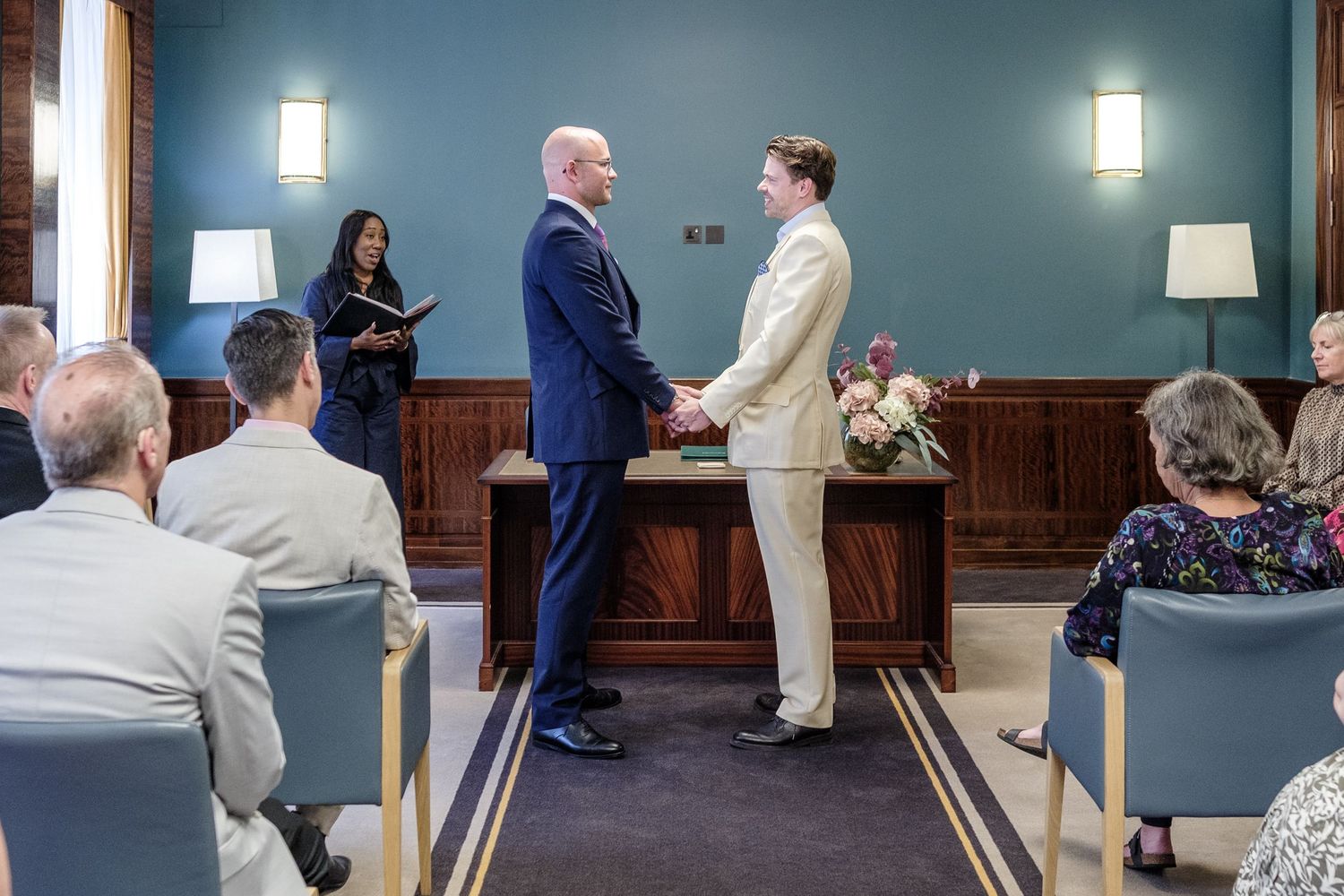 A wedding ceremony in a classic church sanctuary with warm lighting and dark wood wall panels.