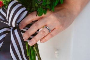 Close-up detail of hands styling fresh green parsley leaves against a black and white striped background.