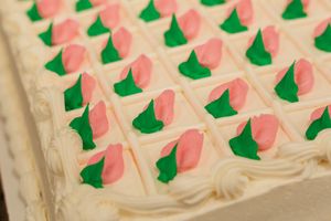 Pink and green floral pattern decorates the surface of a white wall or ceiling in a repeating design motif.