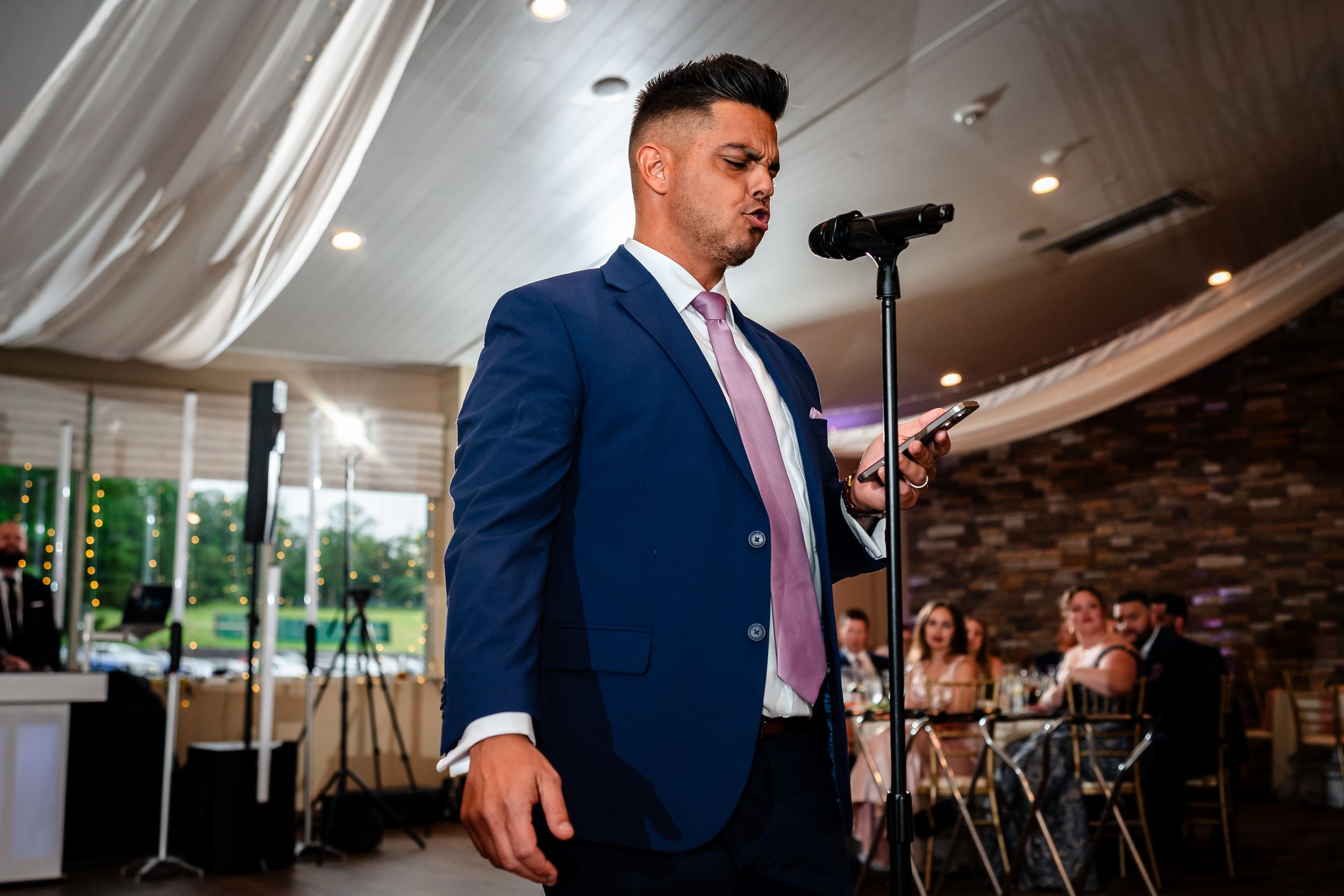 Wedding reception speeches being delivered at an elegant indoor venue.