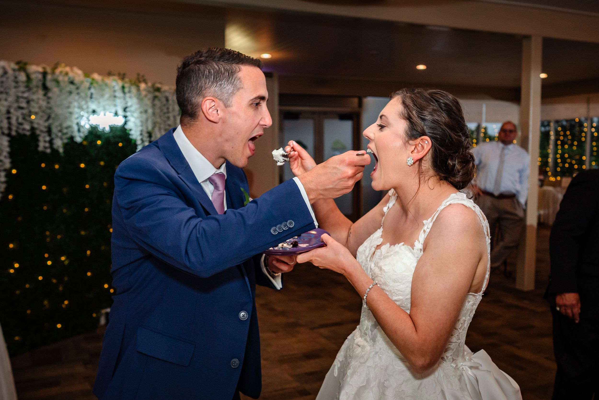 Joyful moments shared during wedding cake cutting ceremony at reception.