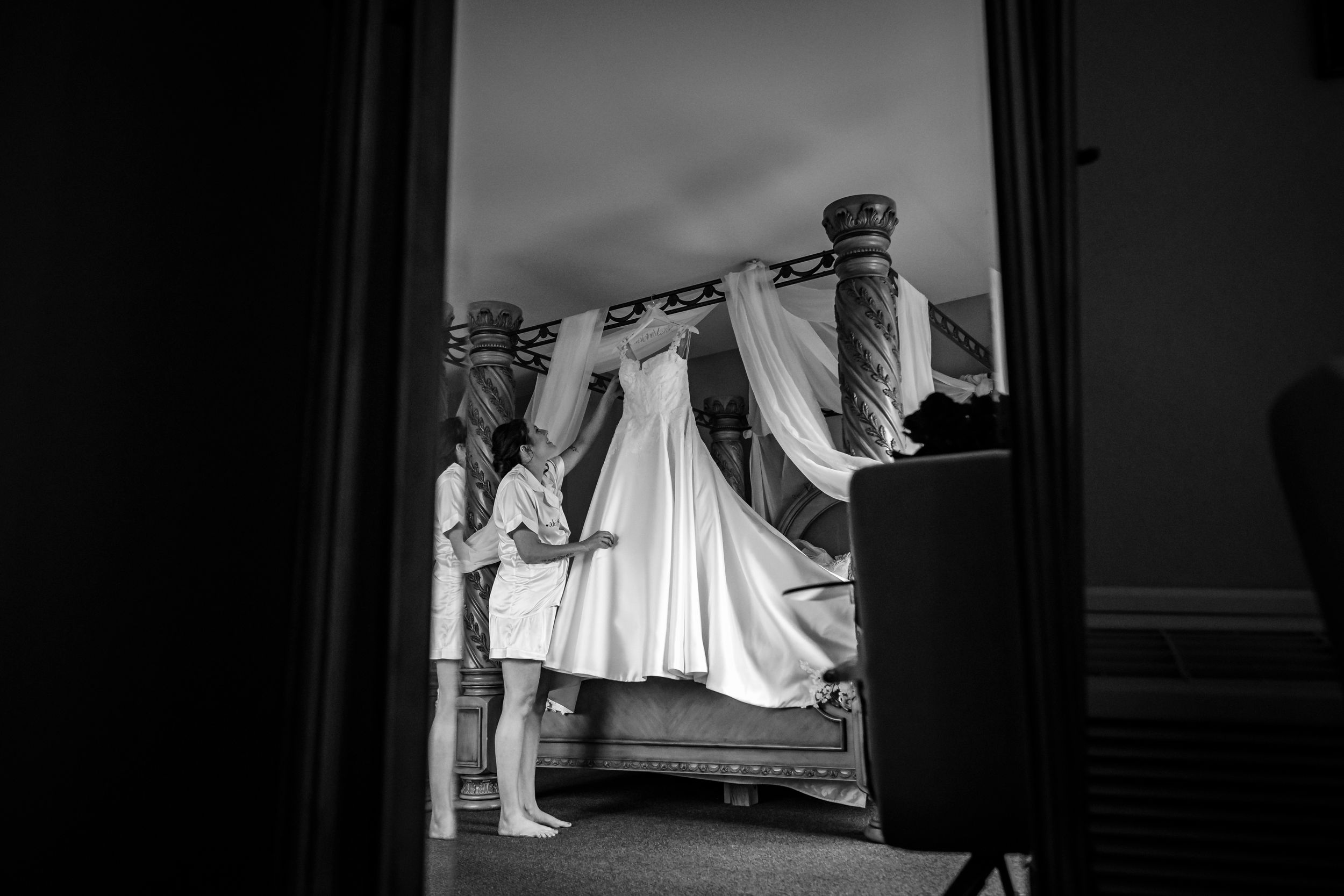 Black and white photo series showing wedding dress preparations in a room with natural light.