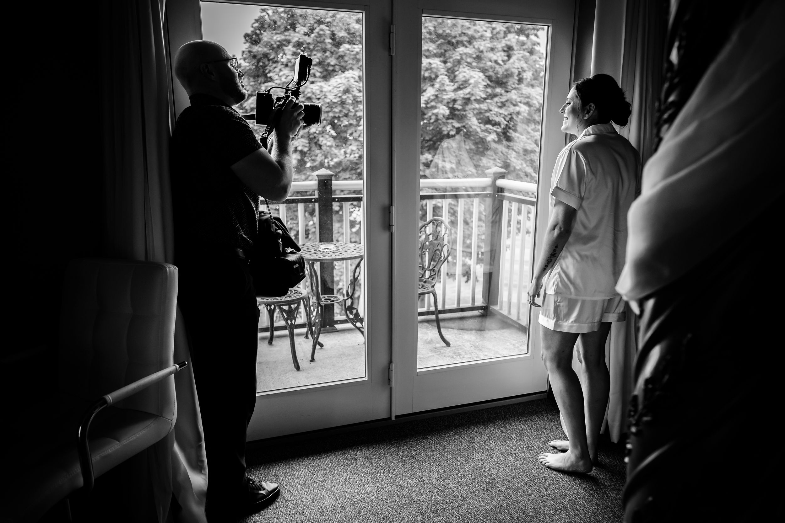 Silhouettes by a window during wedding day preparations.