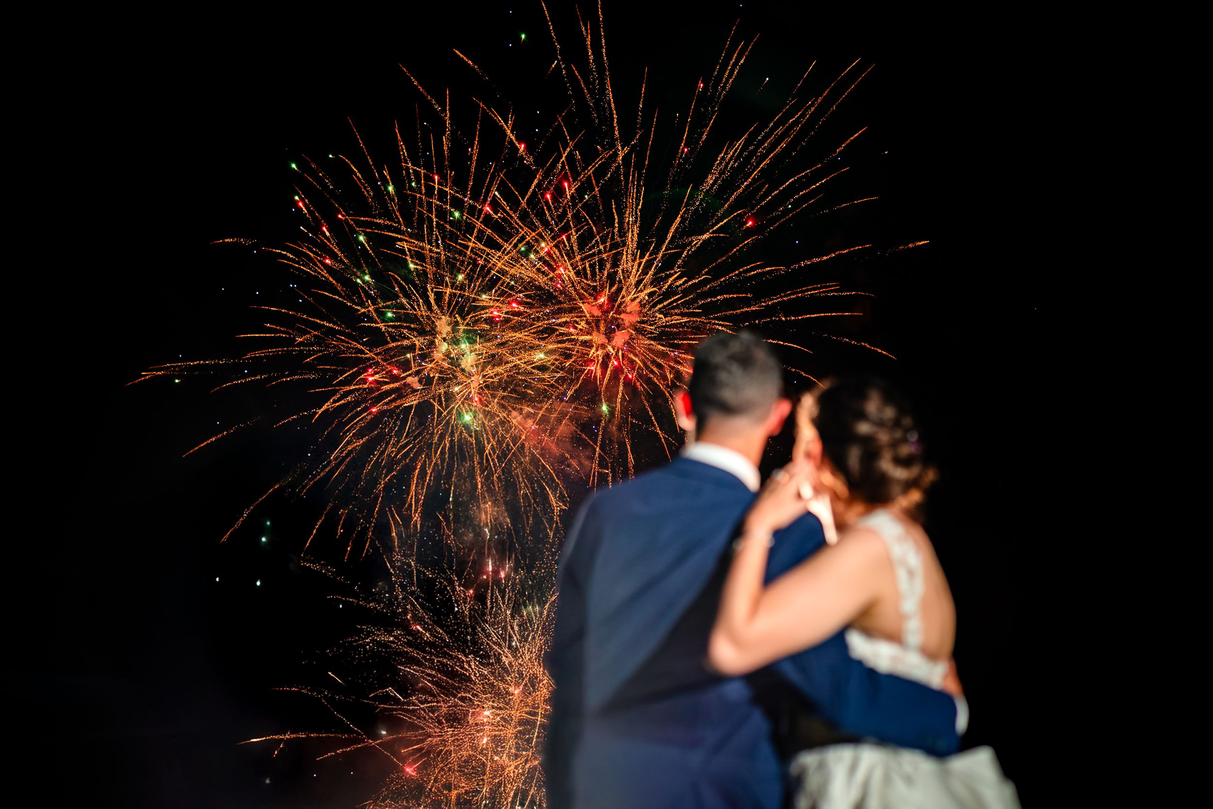 Beautiful fireworks display lighting up the night sky in red and gold bursts.