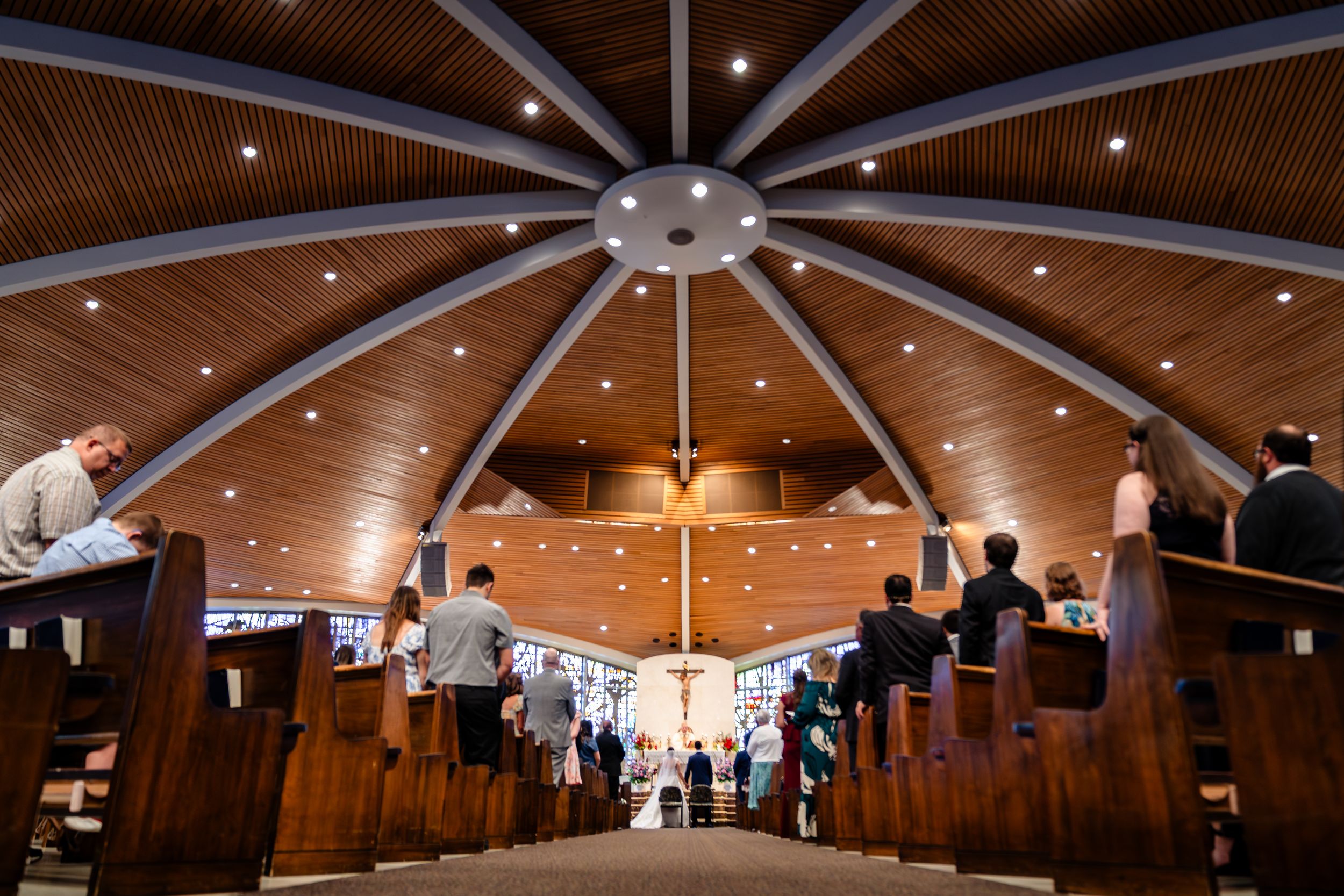 Interior view of modern church architecture with wooden ceiling beams forming a geometric star pattern.