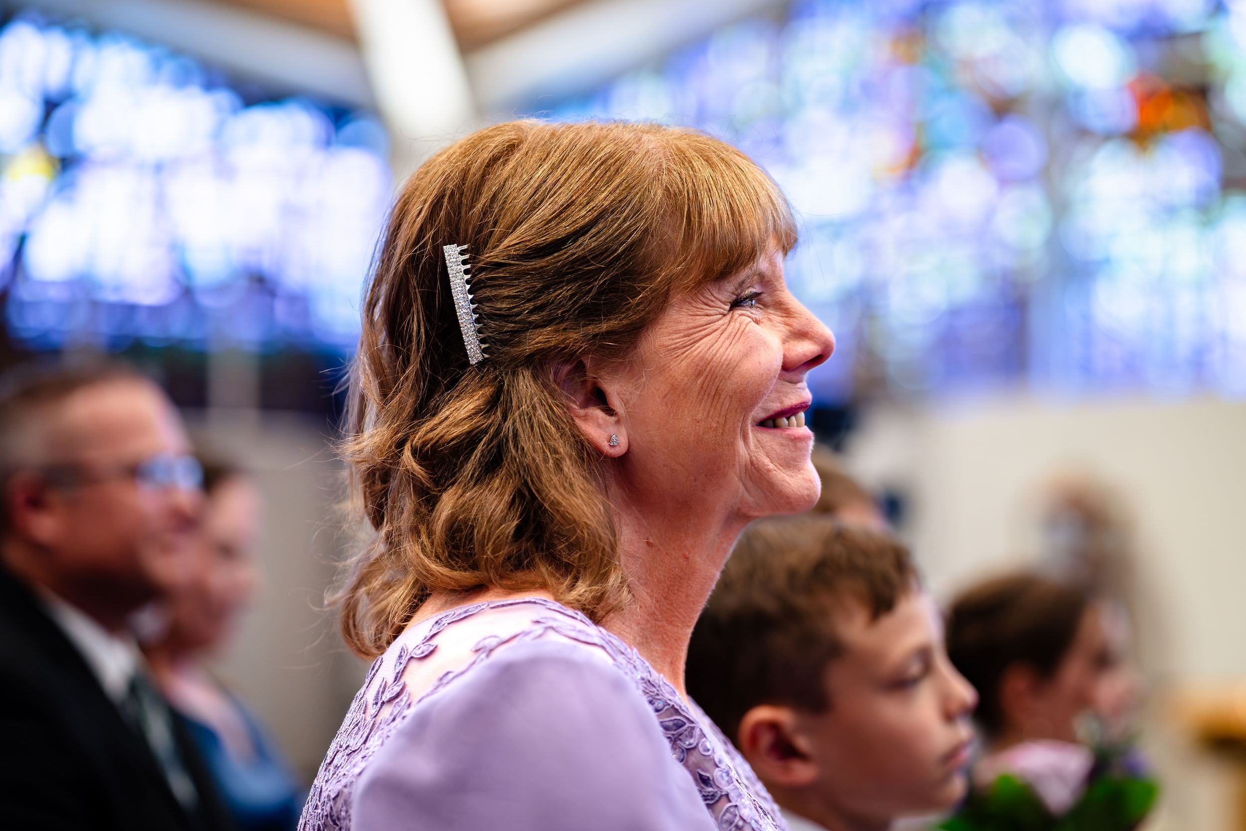 Joyful moment captured during a wedding ceremony with stained glass windows in background.