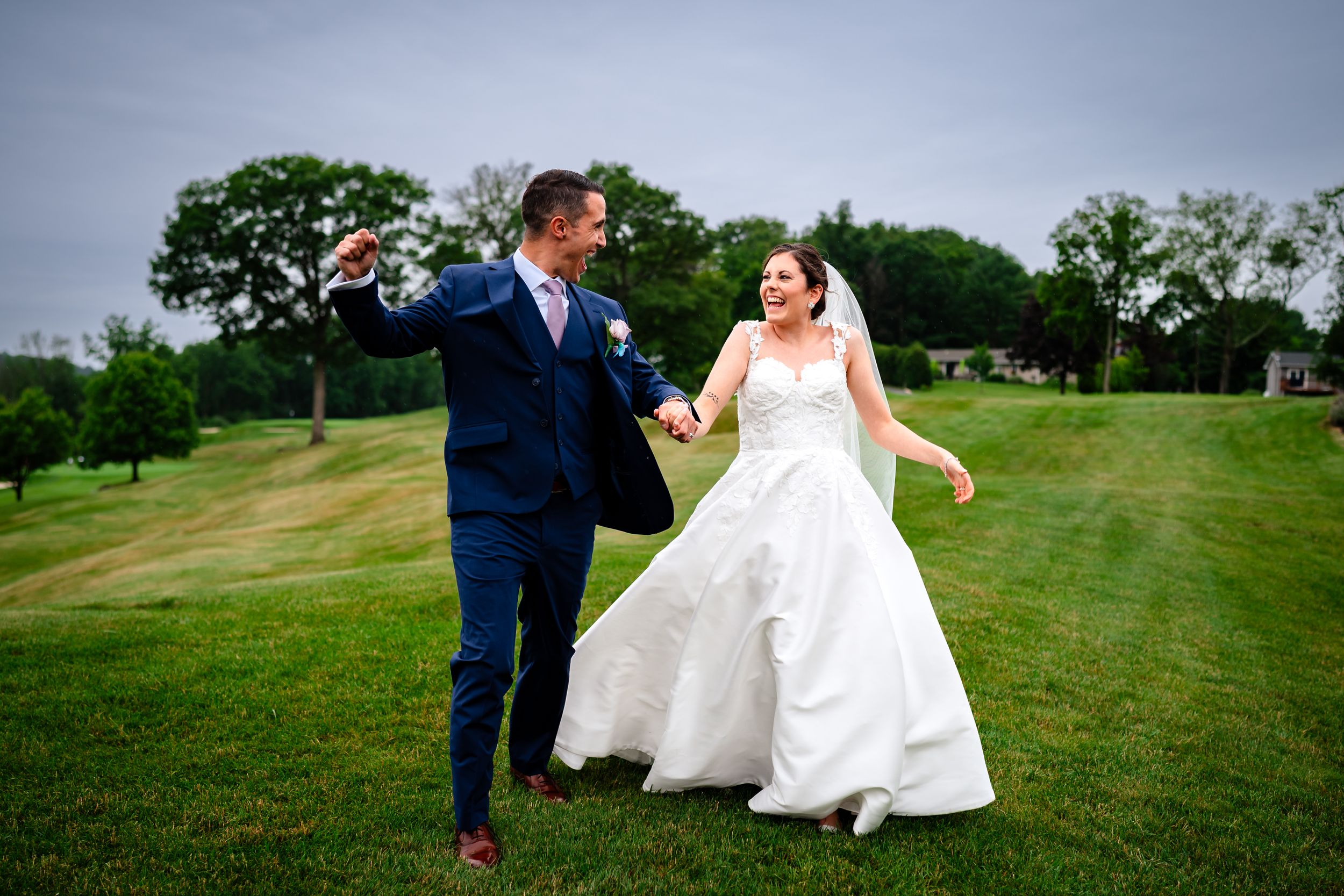 Joyful newlyweds walking together on lush green golf course during wedding celebration.