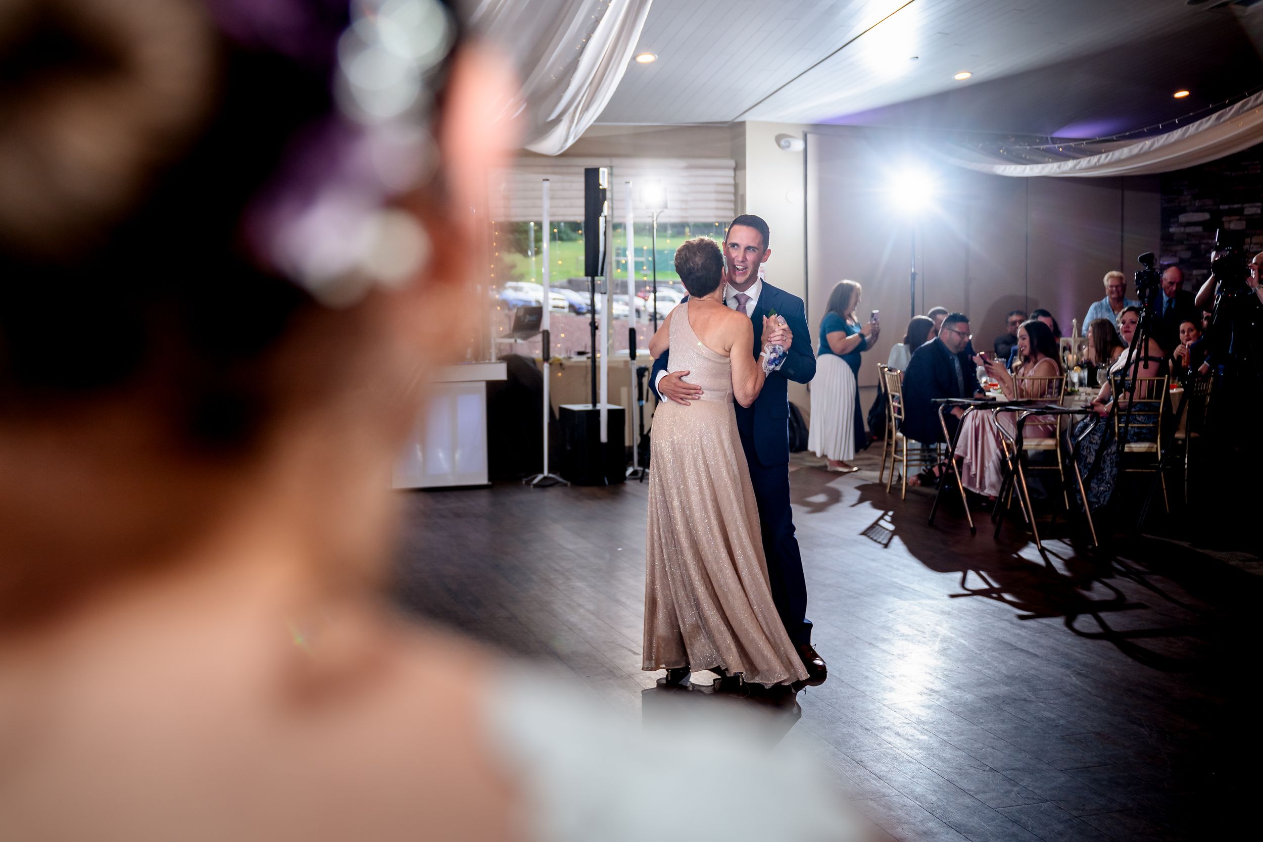Wedding reception dance floor with romantic lighting and guests enjoying the celebration.