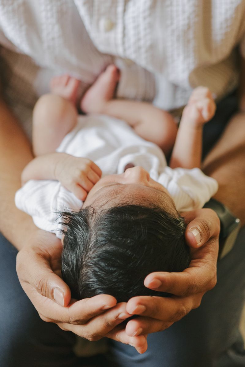 Dad holding newborn baby’s head in his hands, detail portrait NYC
