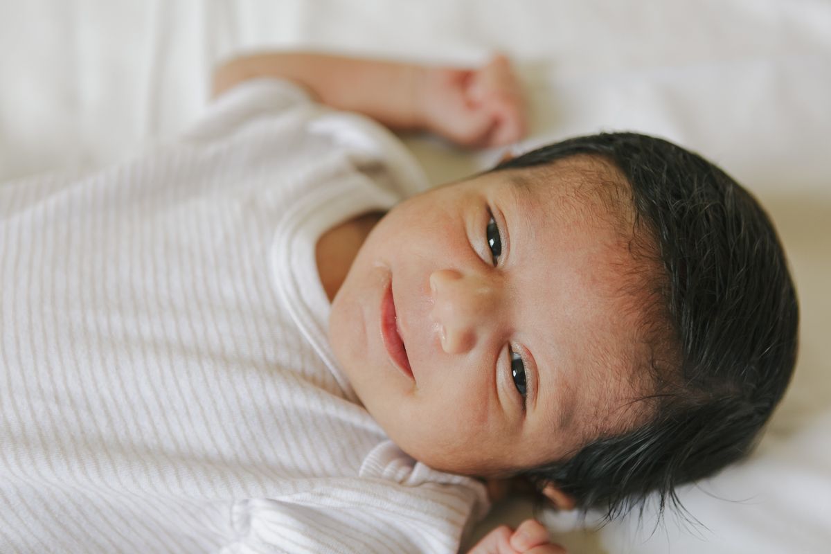 Smiling newborn baby close-up portrait during at-home session in NYC