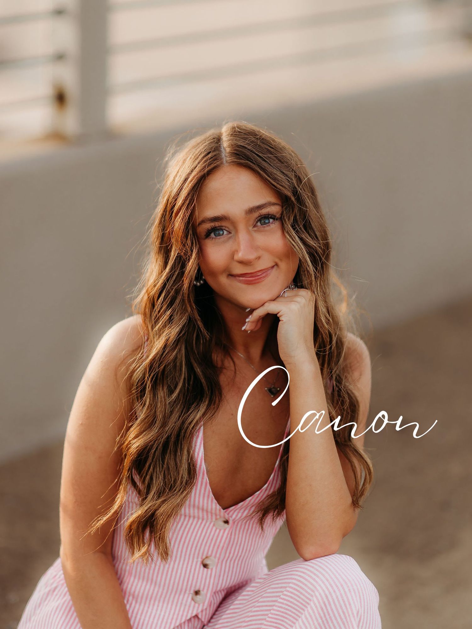 A pink and white striped button-up dress is shown in a natural light setting with soft styling.