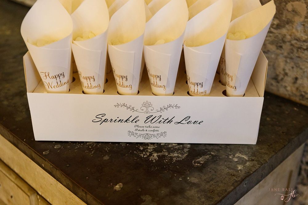 White paper cones arranged in display holders for wedding confetti or flower petals.