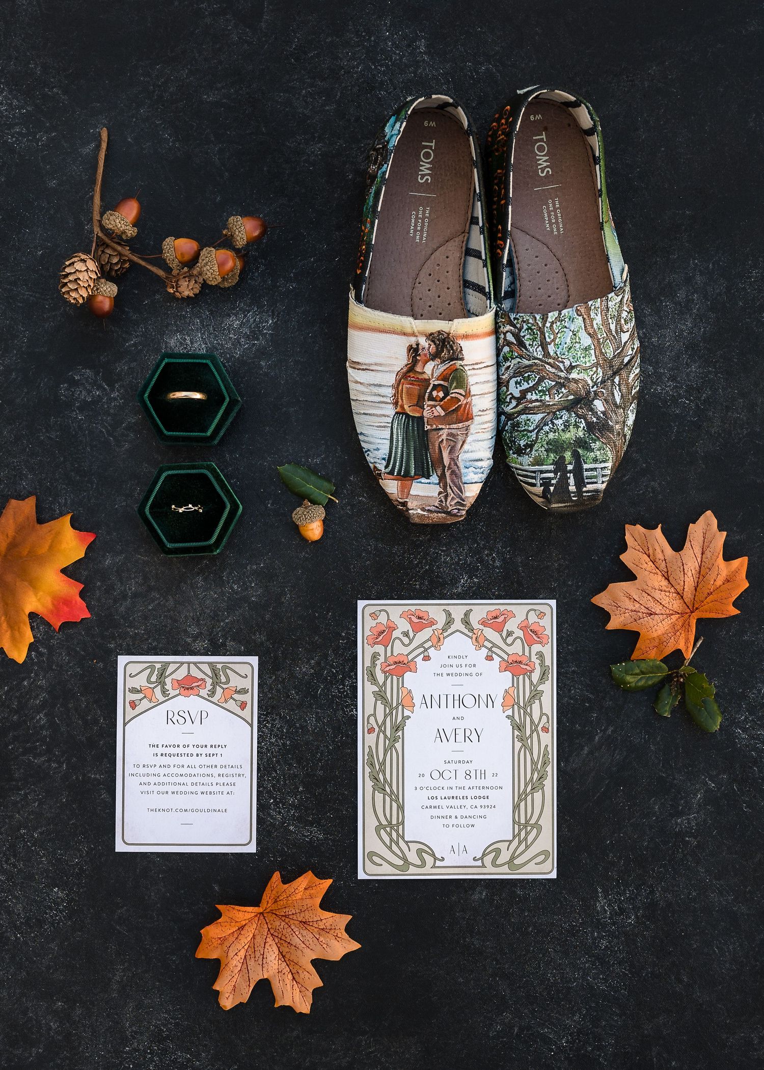 Wedding invitation suite with fall leaves and geometric designs displayed on dark background with brown shoes and decor.