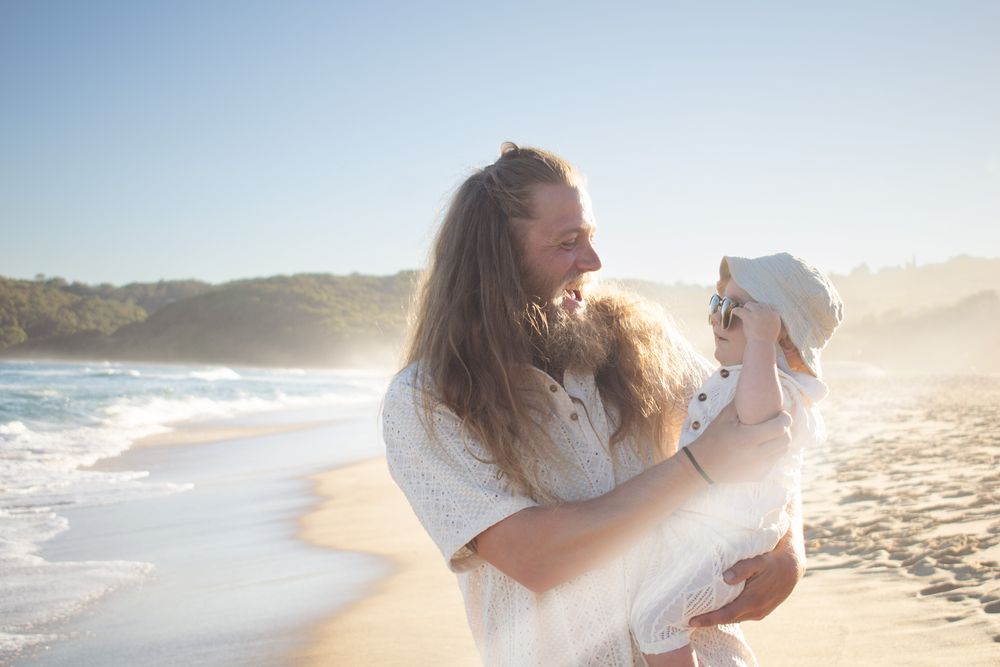 Newcastle family photographer capturing a dad and baby laughing on the beach