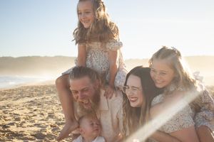Newcastle family photographer capturing a family laughing on the beach