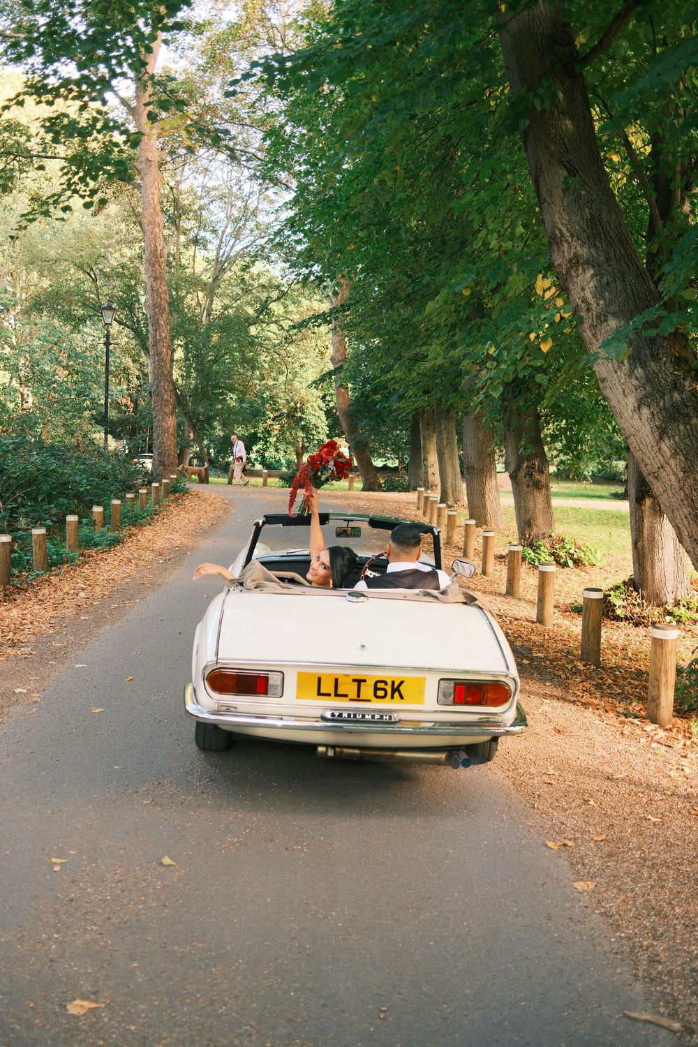 Vintage white wedding getaway car in the lush gardens of Orleans House