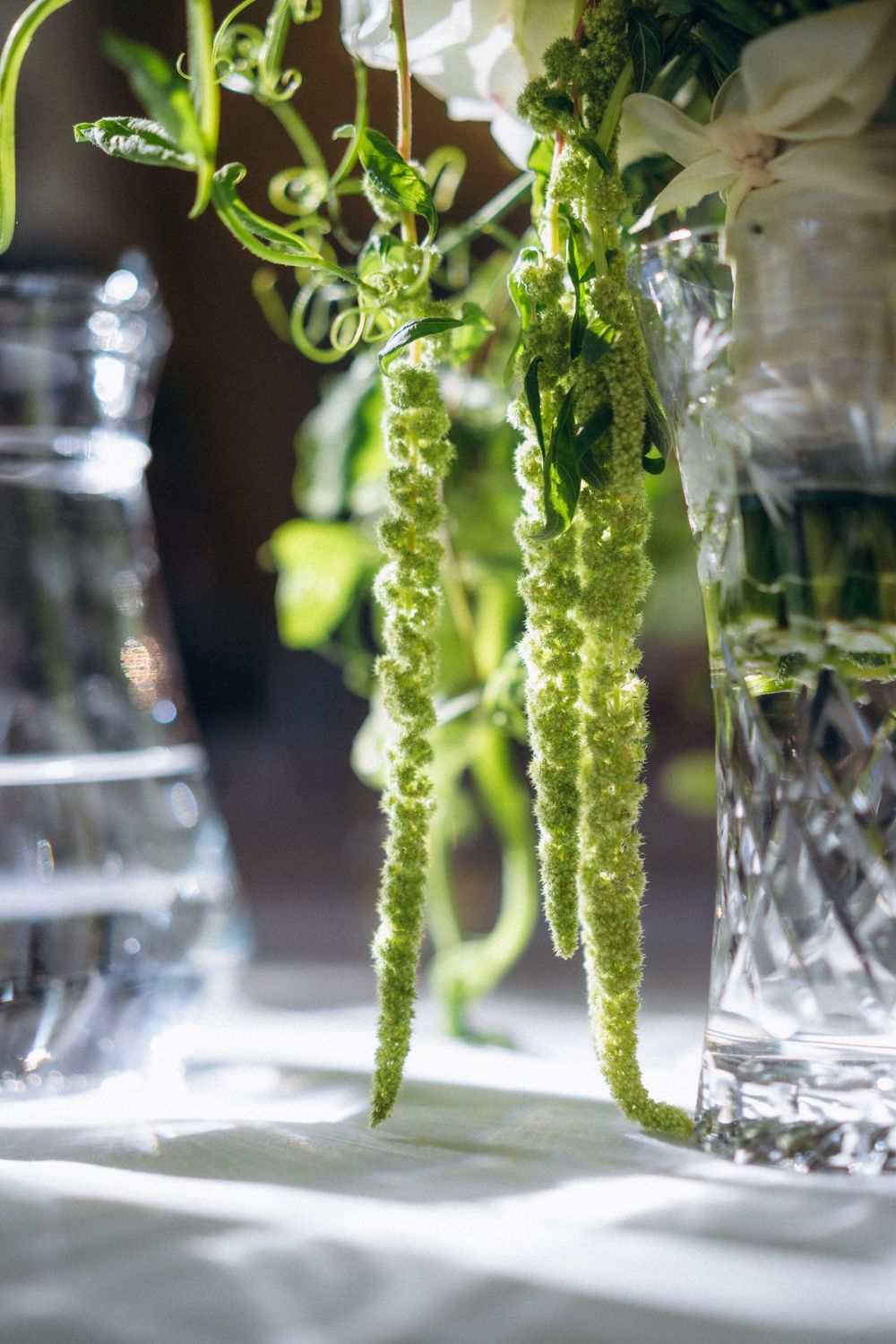 green floral table decoration in sunlight wedding reception styling Espoon Kartano Finland