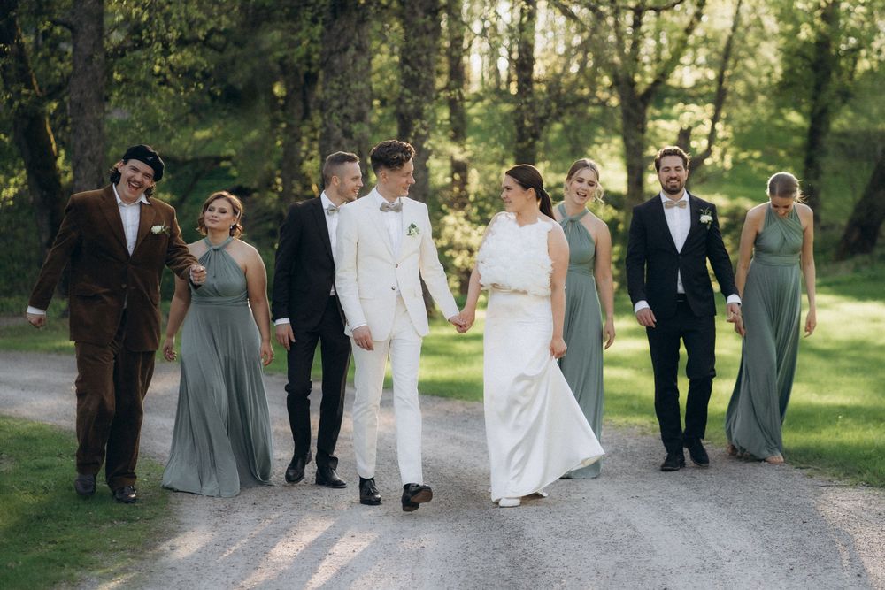wedding couple walking with bridal party in forest path Espoon Kartano documentary wedding photography Finland