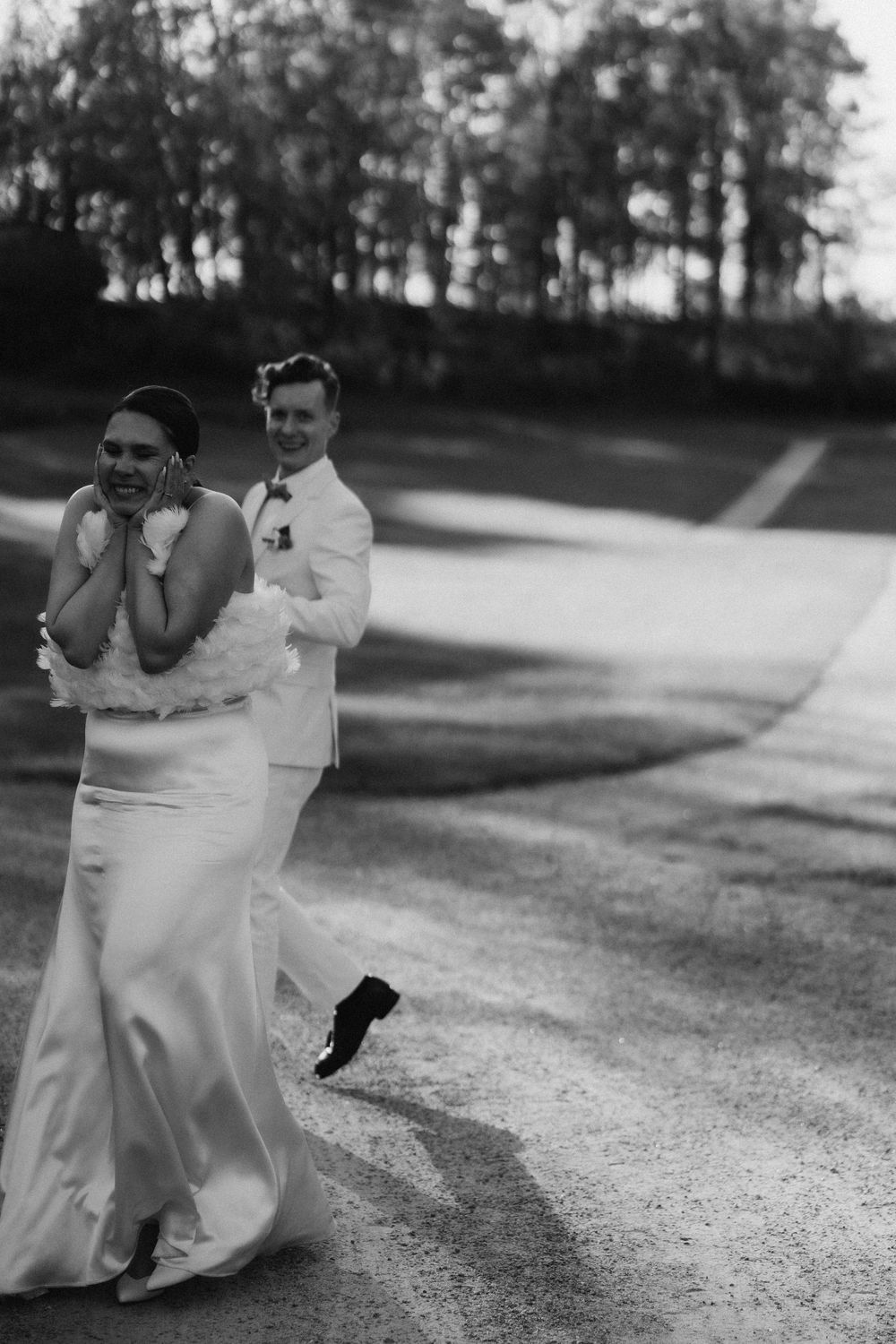 bride and groom walking together in soft evening light artistic black and white wedding photography Espoo