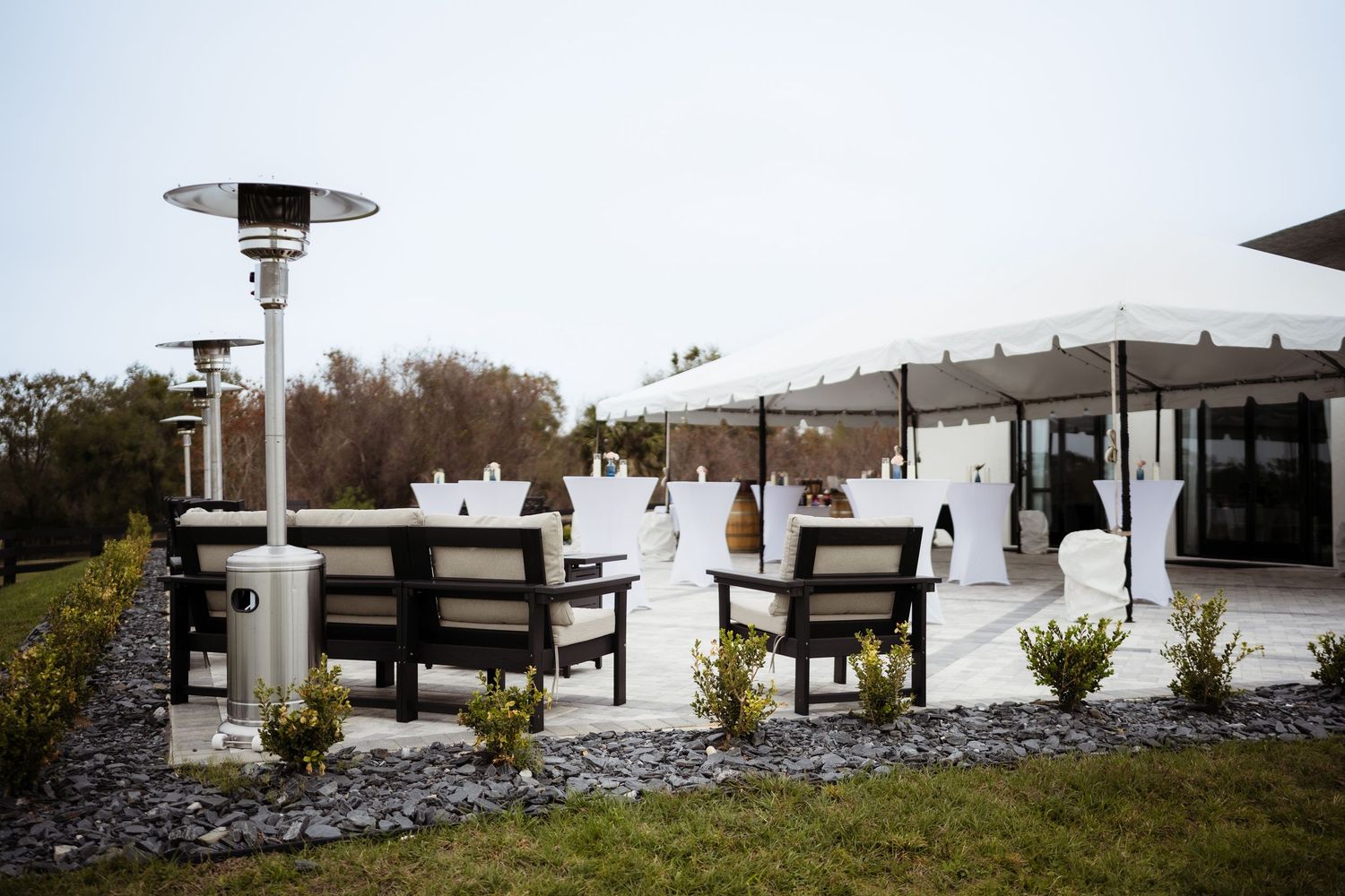 Outdoor patio heaters provide warmth to multiple seating areas at a modern restaurant terrace.