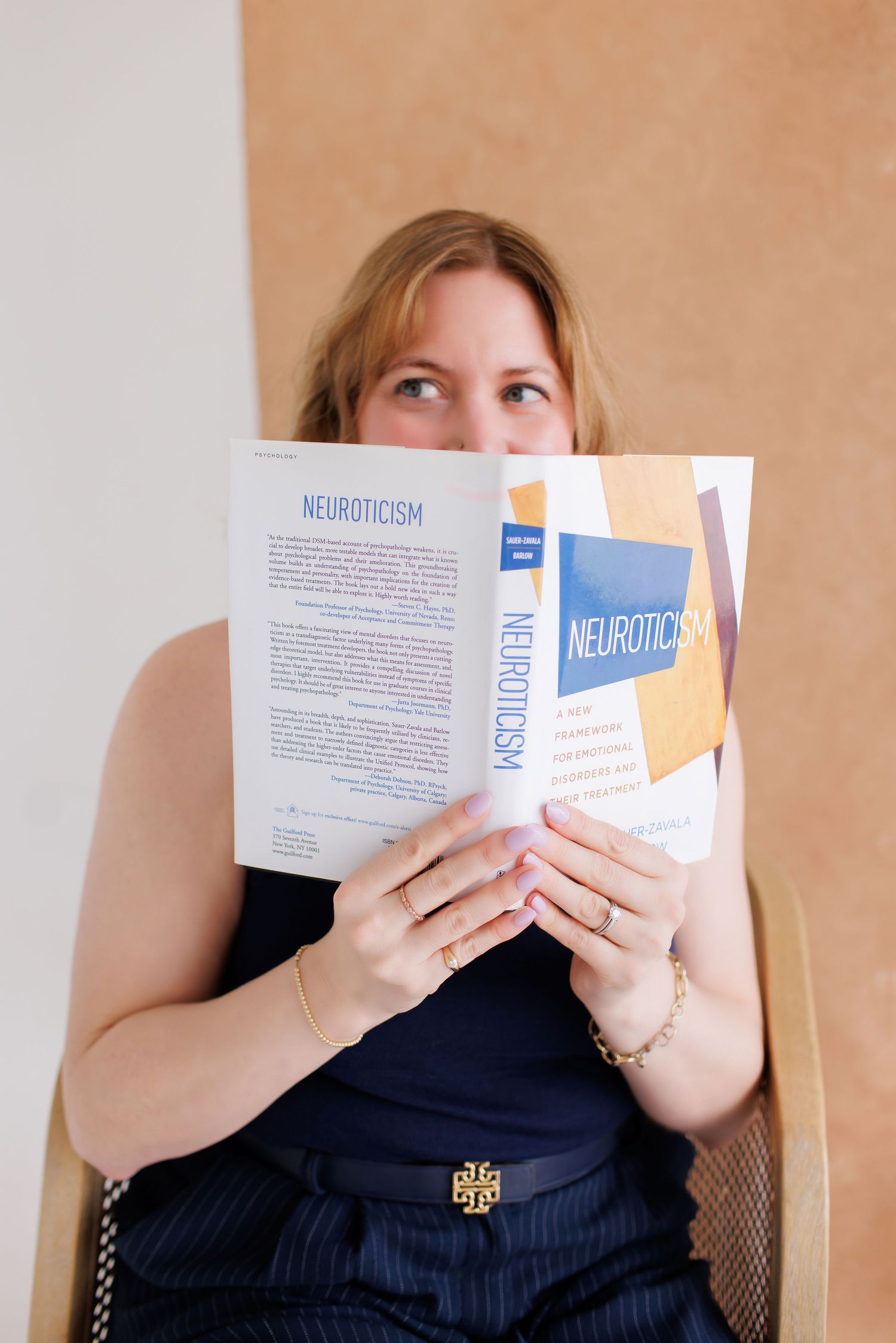 A person in black holds up white business cards with blue text reading 'Neuroticism' in a progressive sequence.