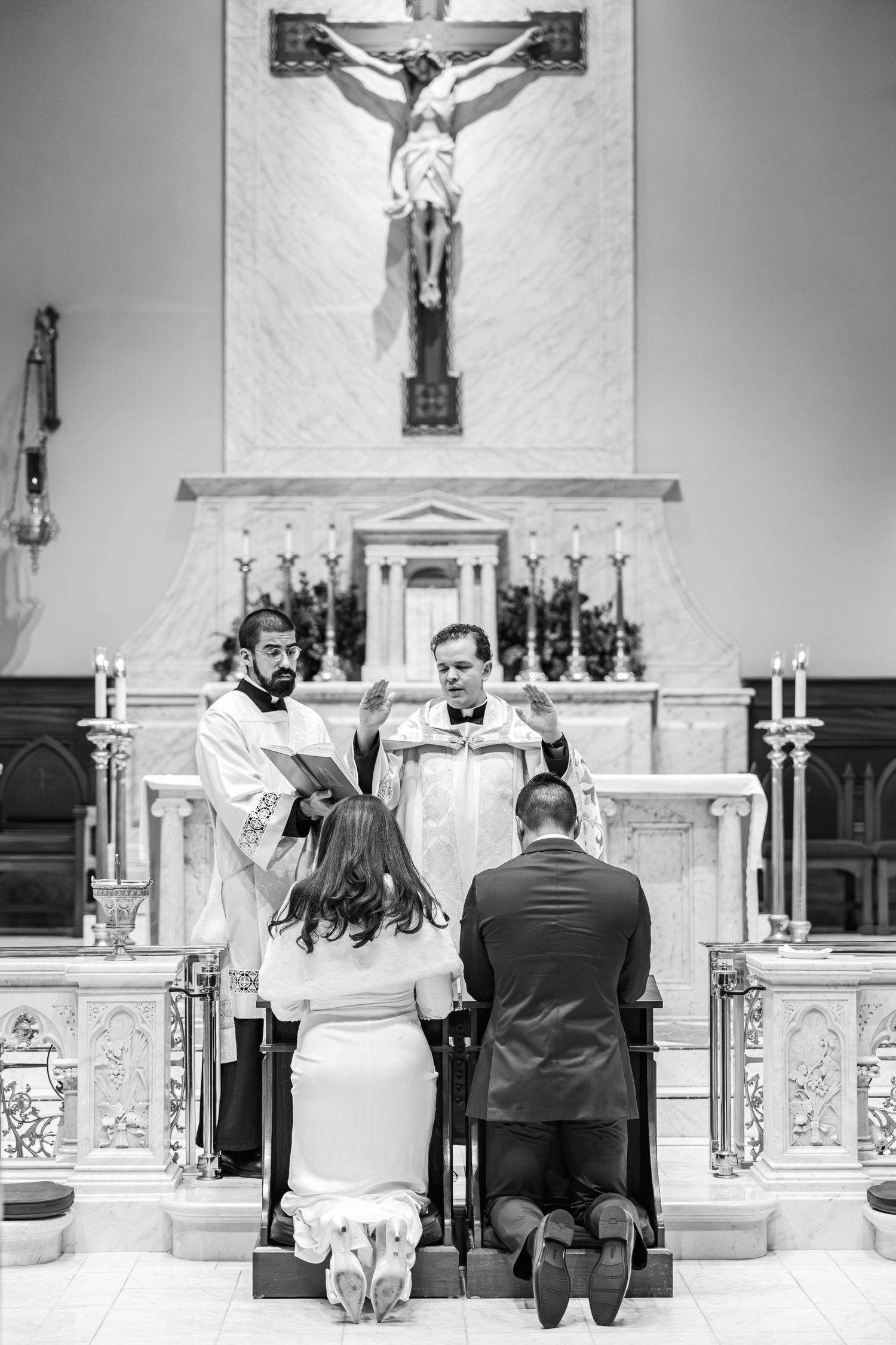Black and white photo series showing a couple kneeling at the altar during a traditional Catholic church wedding ceremony.