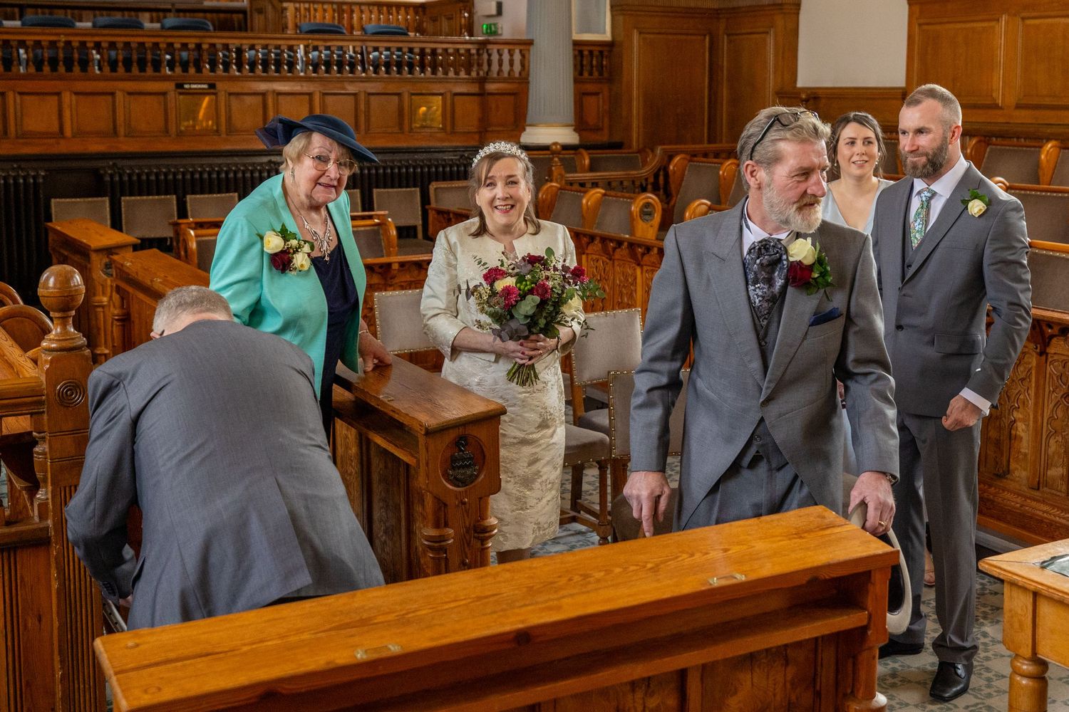 Bride and groom leave ceremony room smiling with family at Southport Town Hall wedding, relaxed documentary photography