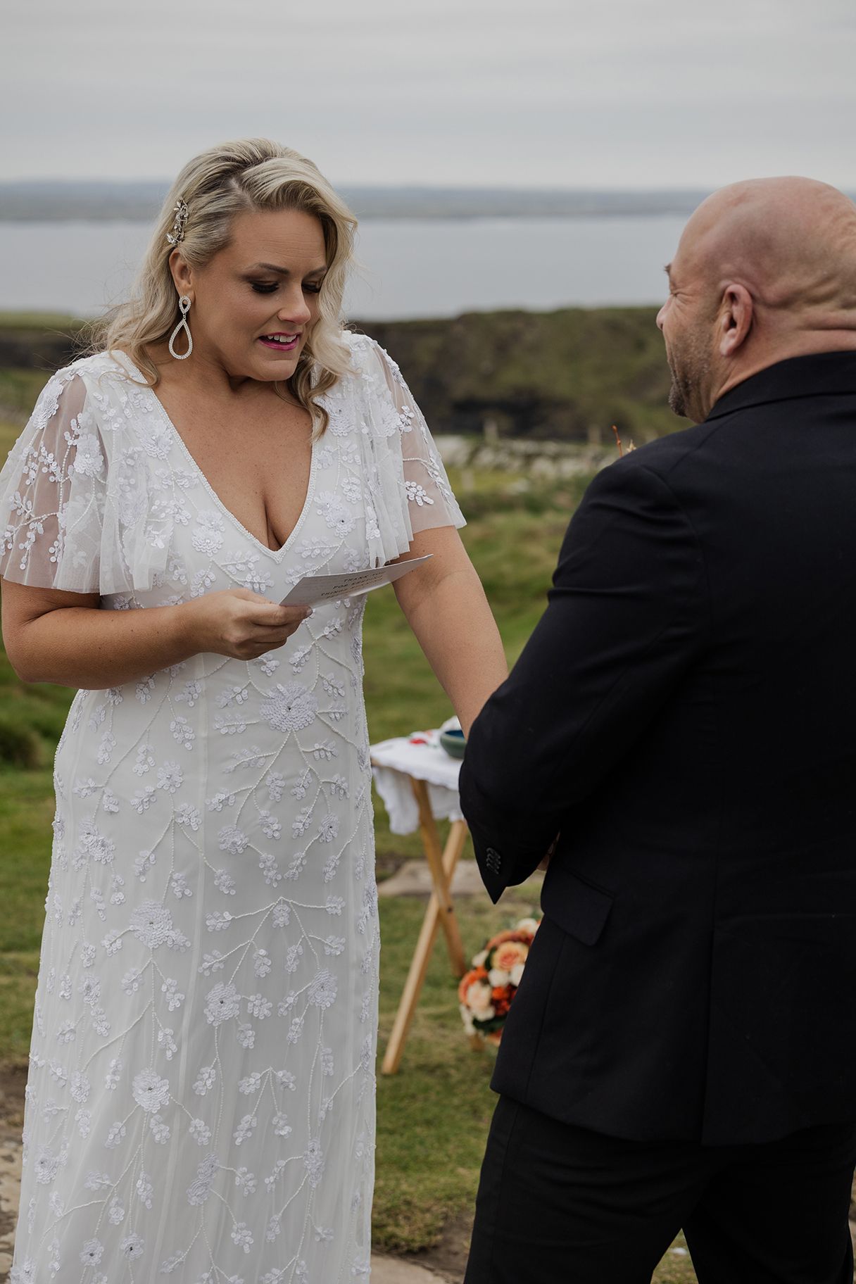 Bride and groom reading vows at Hags Head overlooking the Atlantic Ocean