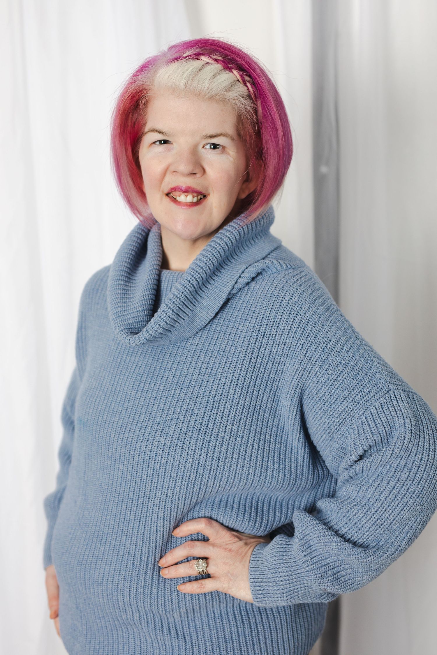 A person wearing a blue knit sweater poses playfully in a sequence of four similar photos.