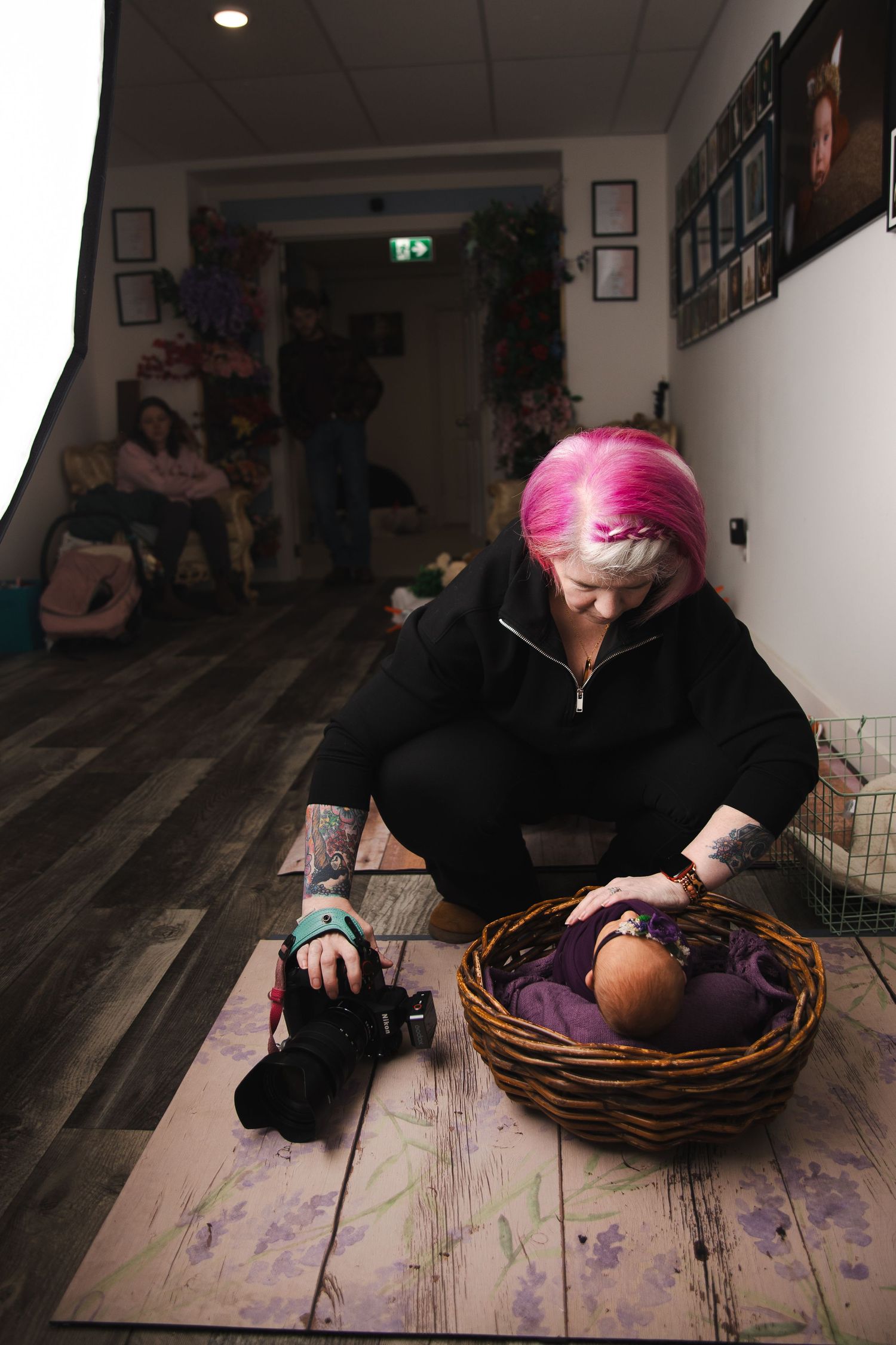 A series of artistic photographs showing someone with pink hair lying down on a wooden floor in progressive poses.