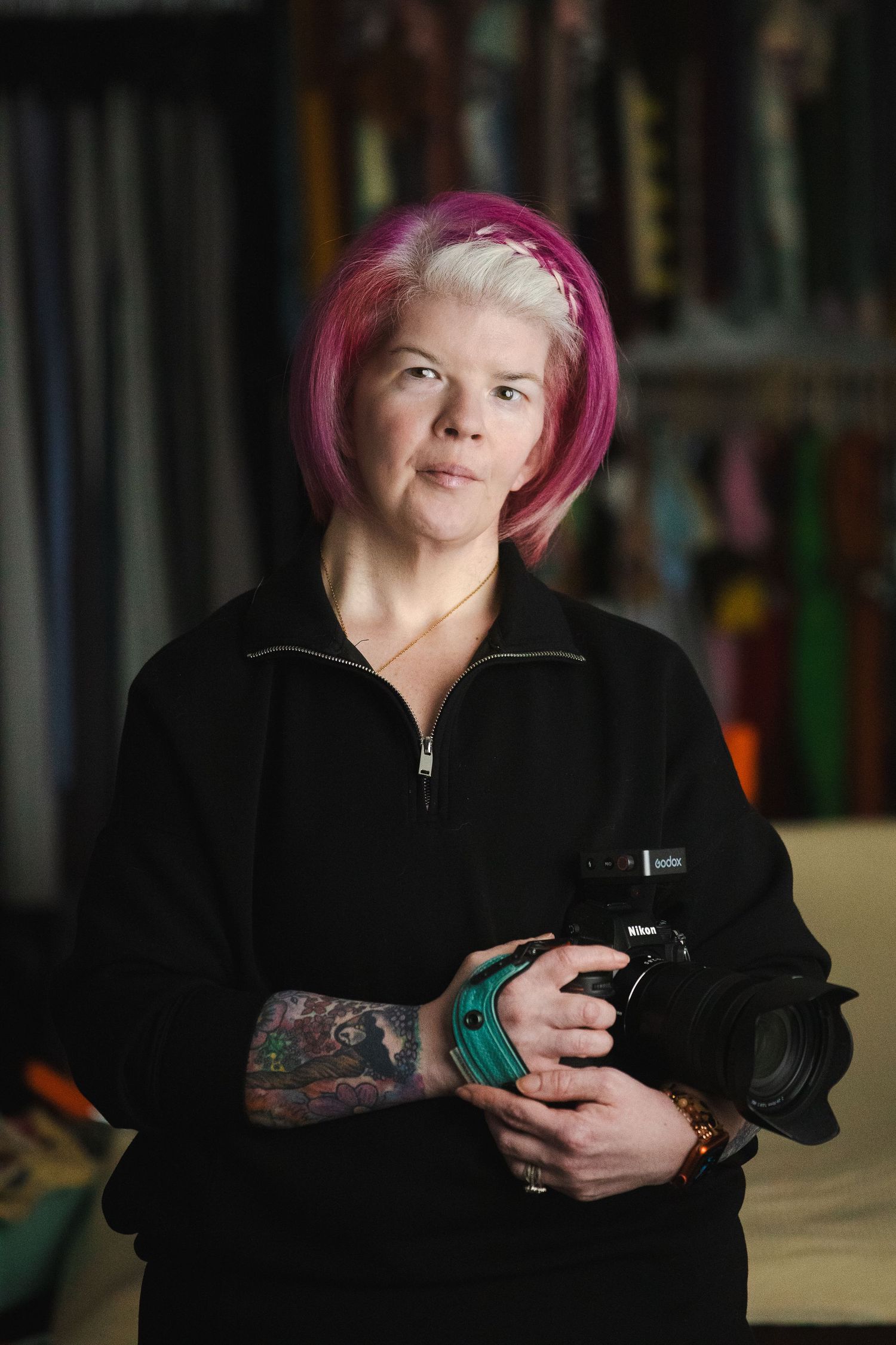 Person with pink hair wearing a black jacket holds a phone while looking up in a progressive sequence of photos.