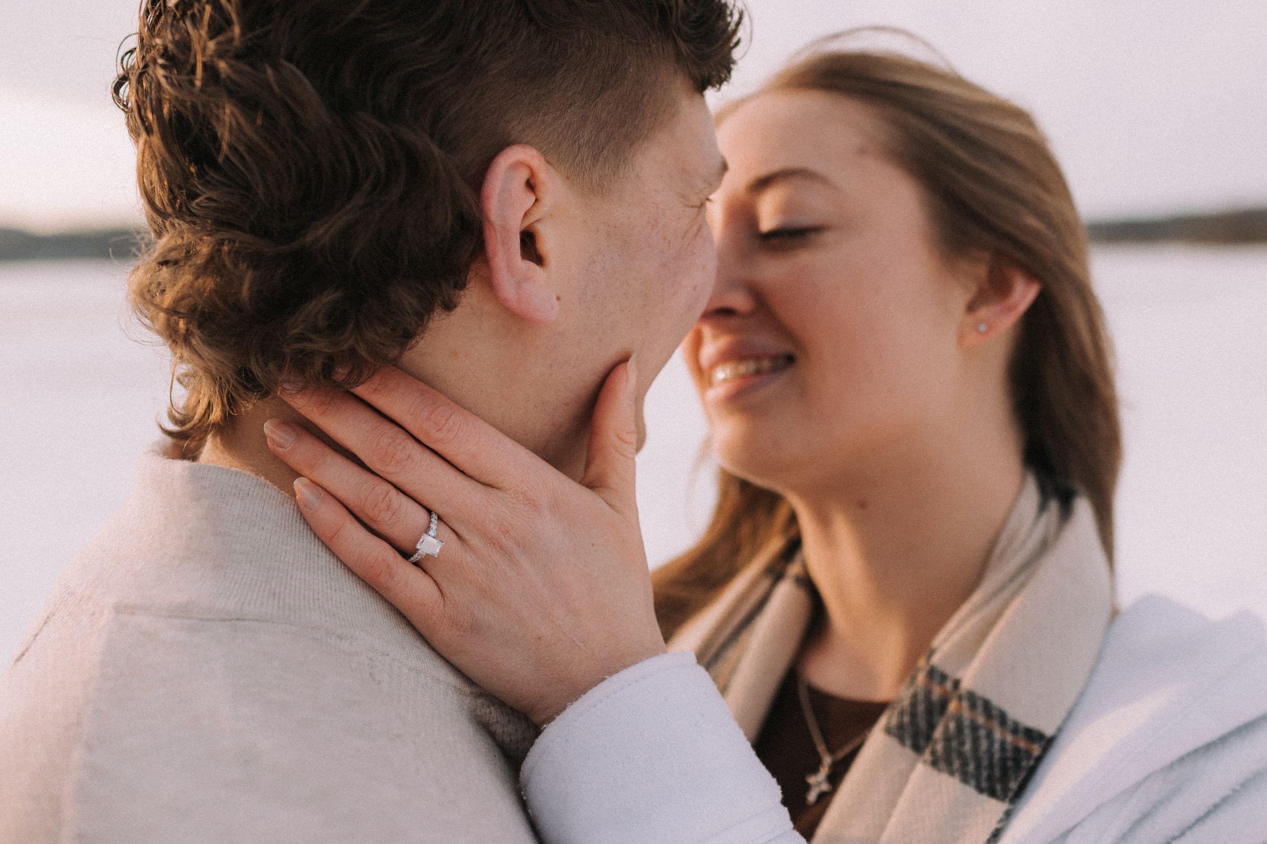 Romantic collage showing five tender kissing moments between a couple in soft, muted lighting.