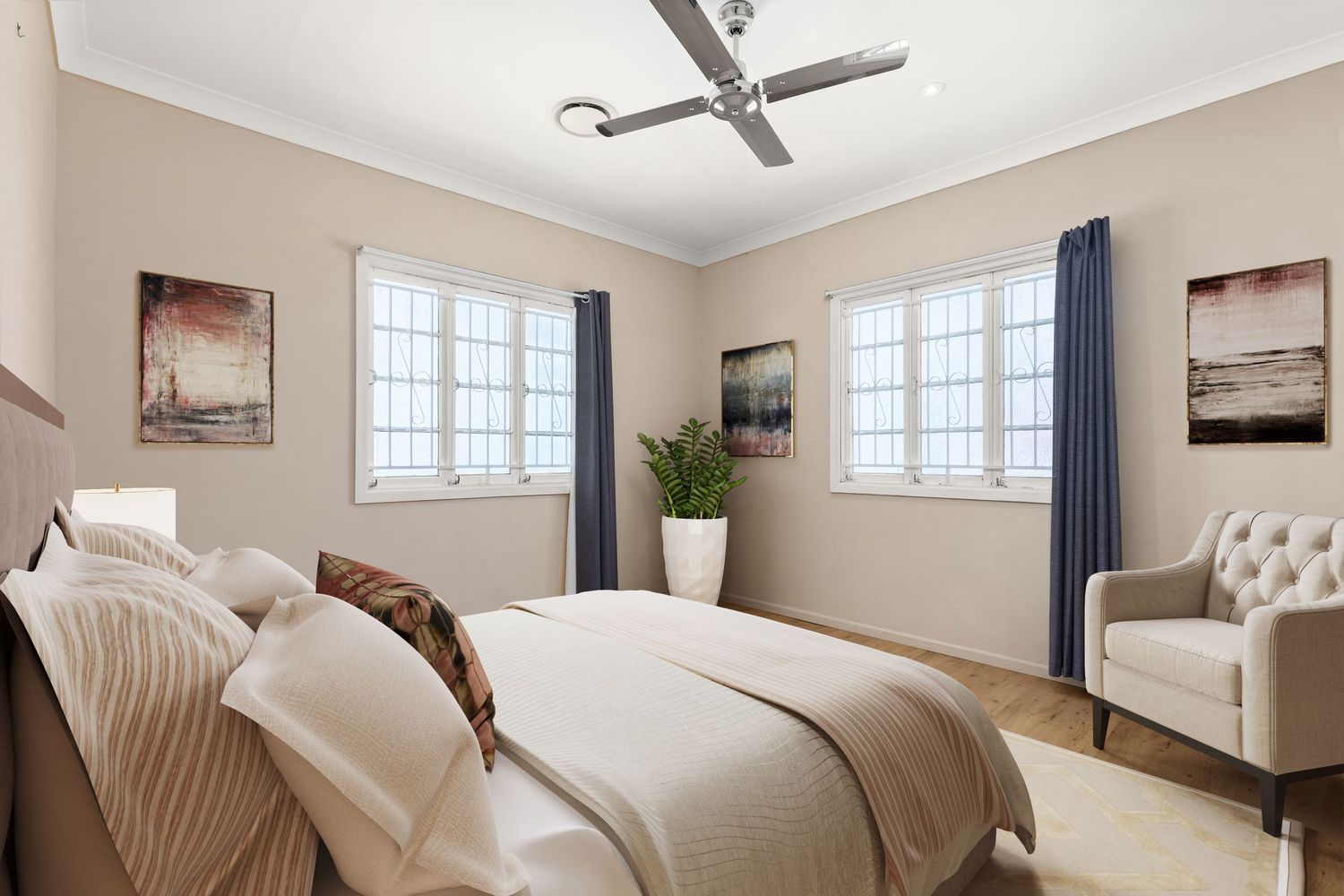 Elegant bedroom with neutral tones, ceiling fan, blue curtains, and classic white window frames.